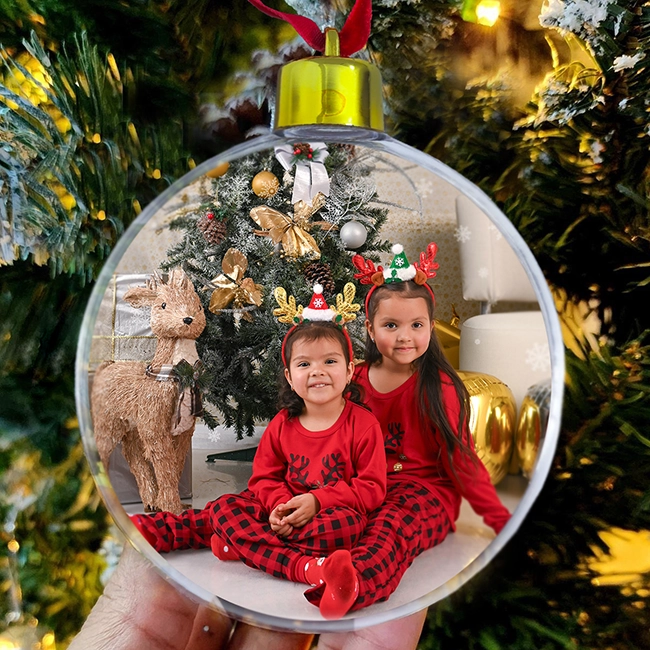 adorno navideño transparente personalizado con foto de niñas colgado en árbol de Navidad